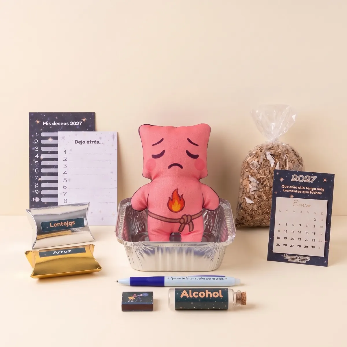 Contenido del kit para quemar el año viejo: muñeco en bandeja de aluminio, viruta, alcohol, fósforos, cajitas de arroz y lentejas, lista de deseos 2027, hoja Dejo atrás, calendario 2027 y lapicero